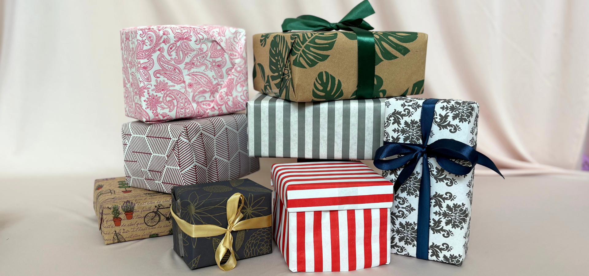 Collection of gift boxes with various patterns and ribbons on a light background