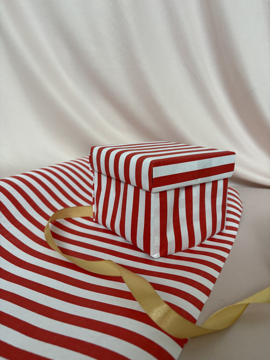 Red and white striped fabric with a gold ribbon on a beige background