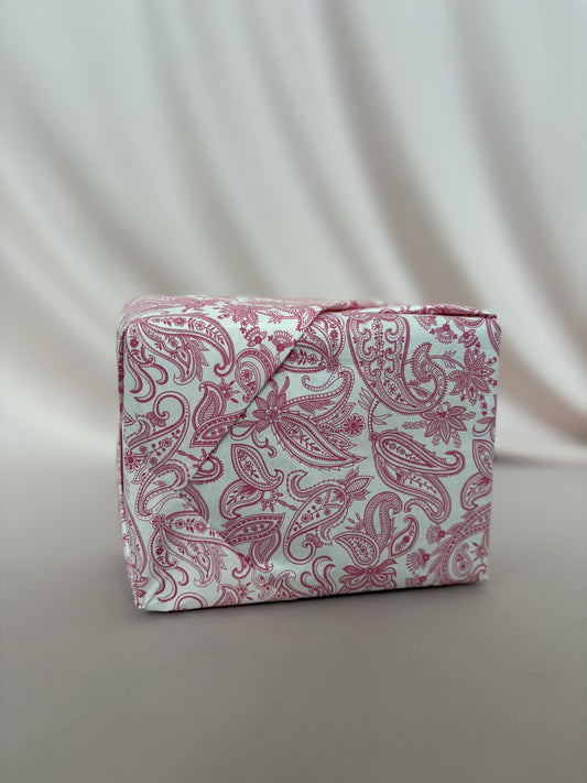 Pink paisley-patterned box on a light gray background