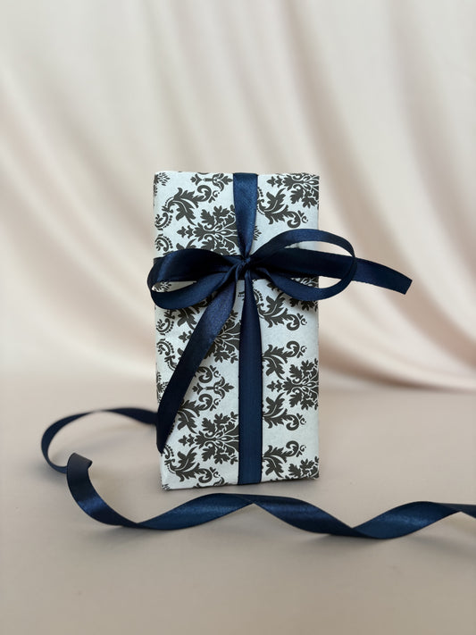 Gift box with blue ribbon on a beige fabric background