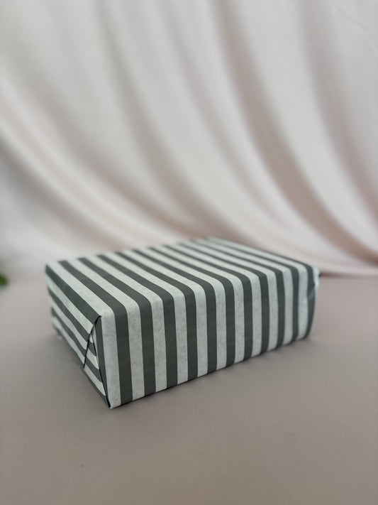 Rectangular box with black and white striped pattern on a light background