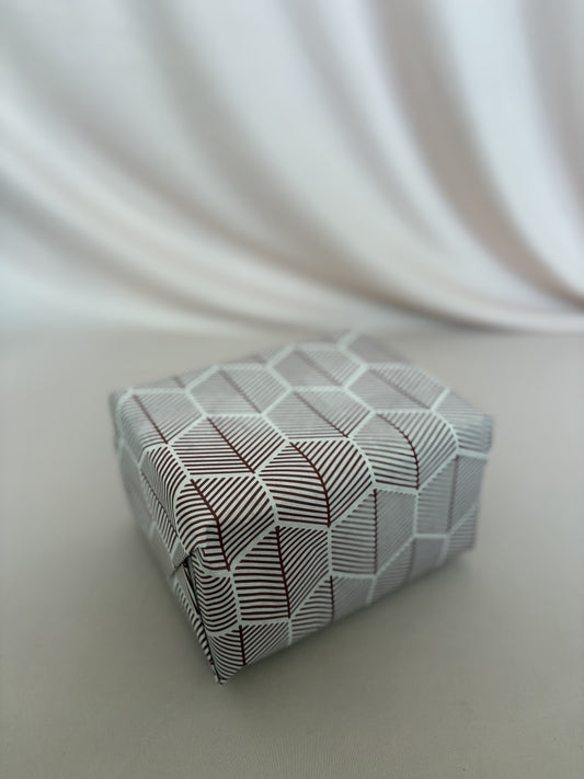 Small rectangular box with geometric pattern on a white fabric background