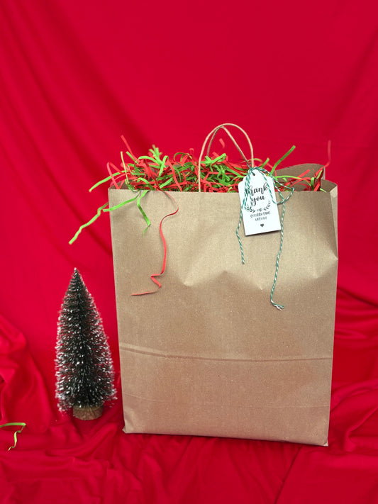 Brown paper bag with greenery and a tag on a red background