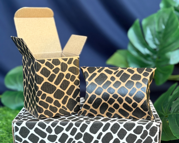 Patterned boxes with a cardboard box on a blue and green leafy background