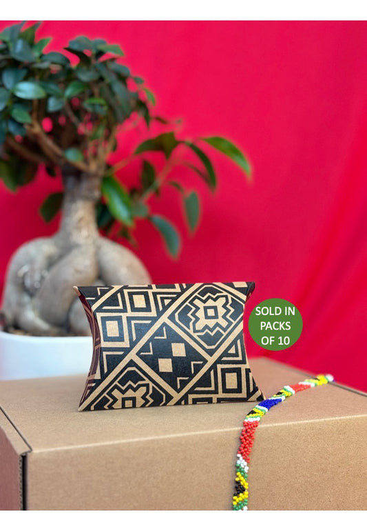 Decorative pillow with geometric pattern on a cardboard box against a red background