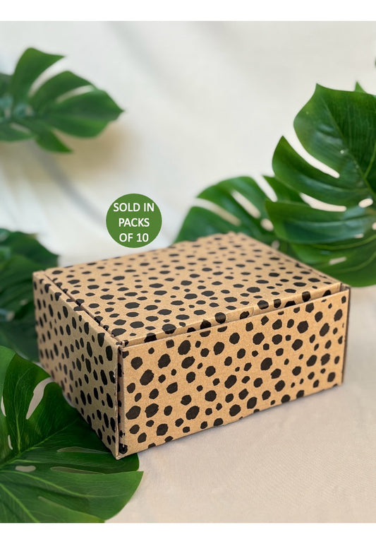 Cardboard box with cheetah pattern on a light background with green leaves