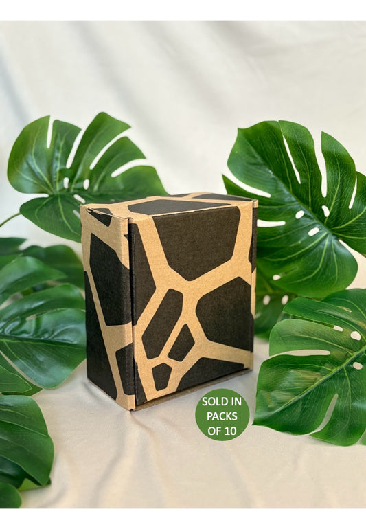 Cardboard packaging with geometric design on a light background with green leaves