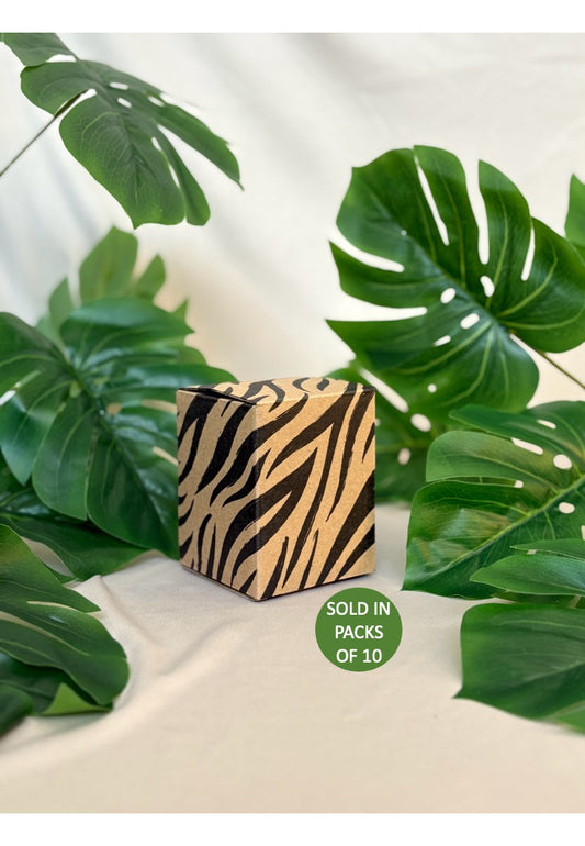 Zebra-patterned cube with green leaves on a light background