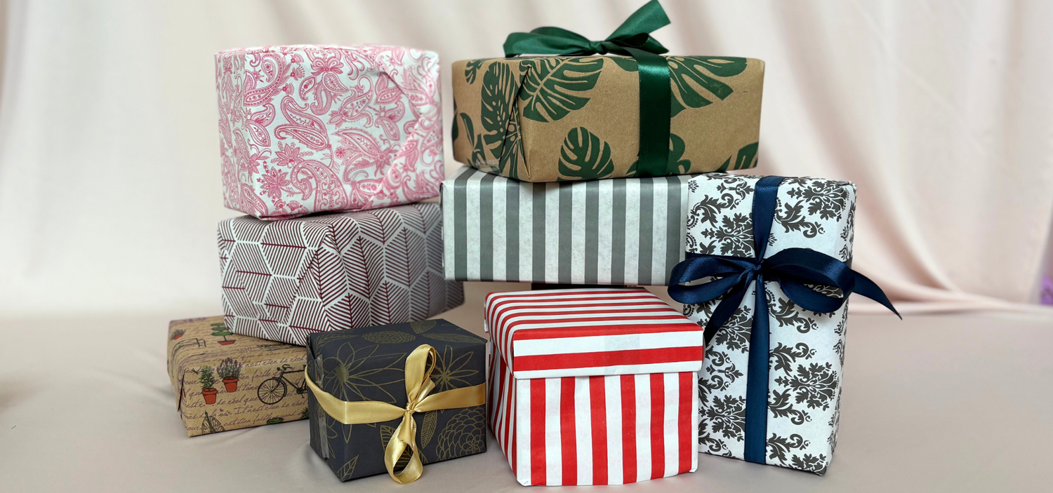 Collection of gift boxes with various patterns and ribbons on a light background
