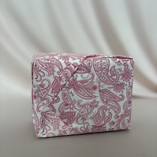Pink paisley-patterned box on a light gray background
