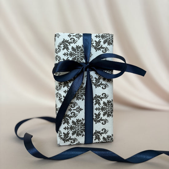 Gift box with blue ribbon on a beige fabric background