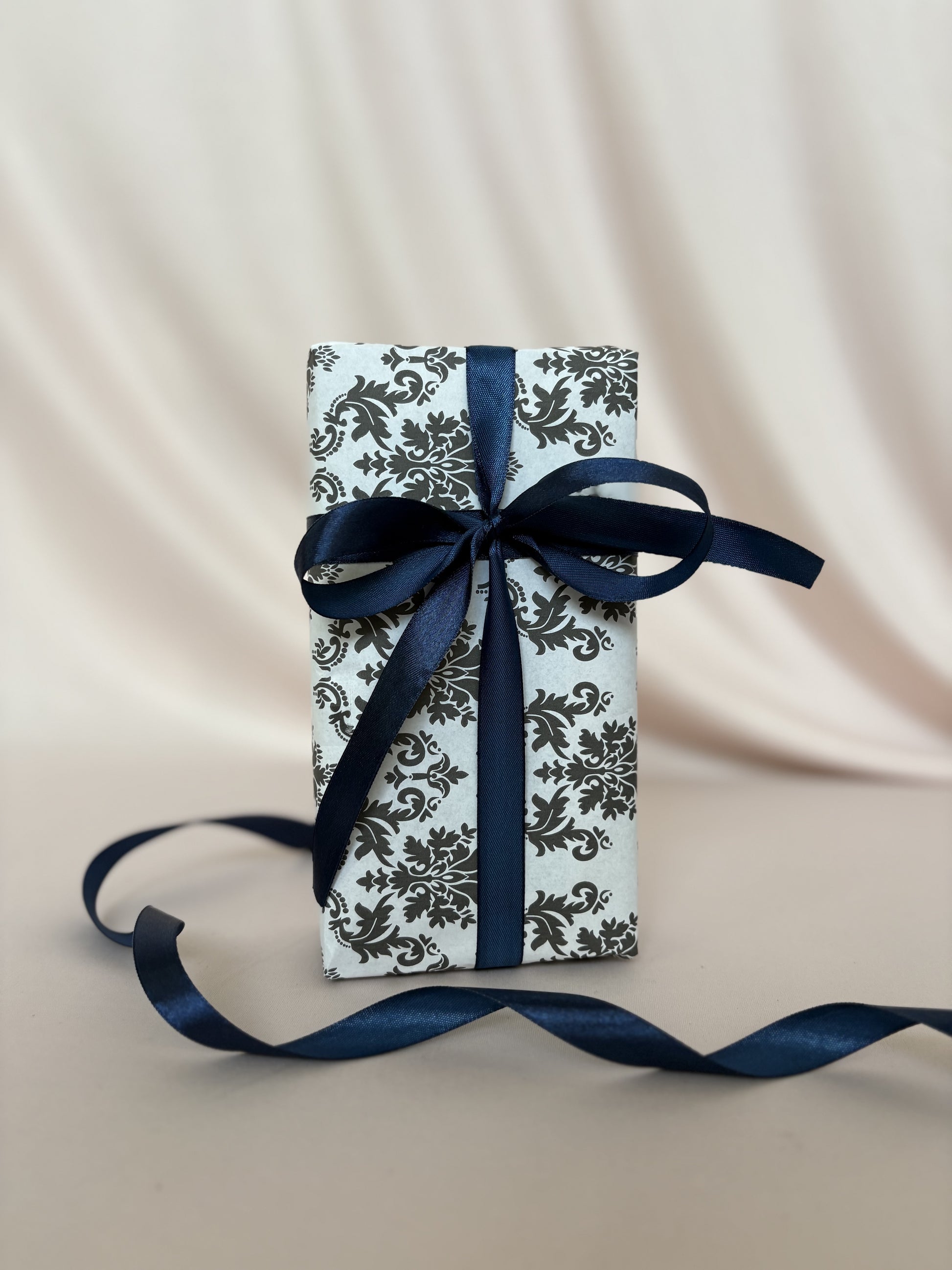 Gift box with blue ribbon on a beige fabric background
