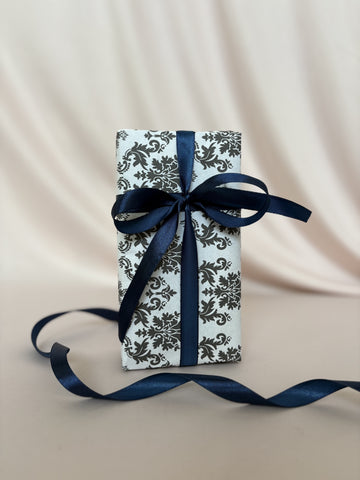 Gift box with blue ribbon on a beige fabric background