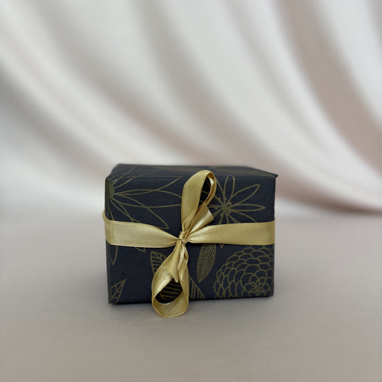 Small gift box with gold ribbon on a white background