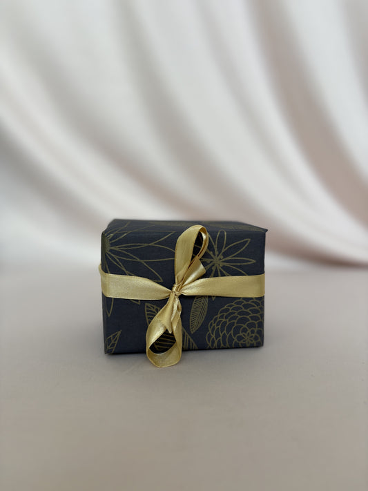 Small gift box with gold ribbon on a white background