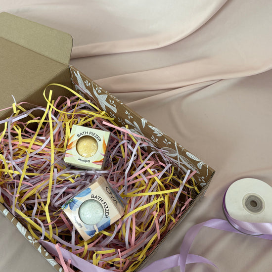 Box with pastel ribbons and small boxes on a neutral background