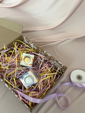 Box with pastel ribbons and small boxes on a neutral background