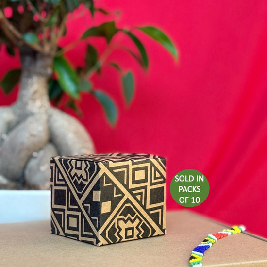 Decorative box with geometric pattern on a wooden surface with a red background