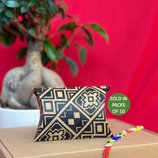 Decorative pillow with geometric pattern on a cardboard box against a red background