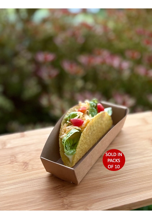 Taco in a cardboard container on a wooden surface with a blurred natural background