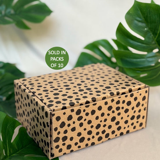 Cardboard box with cheetah pattern on a light background with green leaves