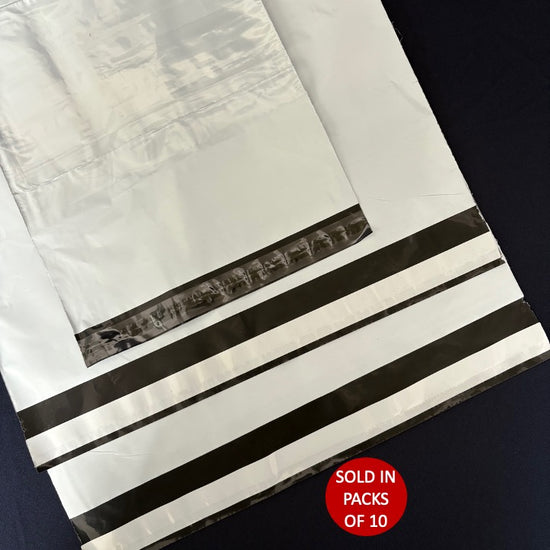 White paper bags with black stripes and a red label on a dark background