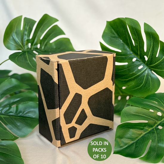 Cardboard packaging with geometric design on a light background with green leaves