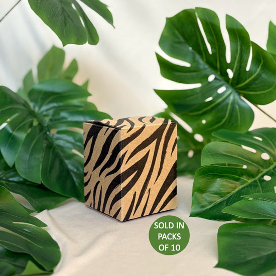 Zebra-patterned cube with green leaves on a light background
